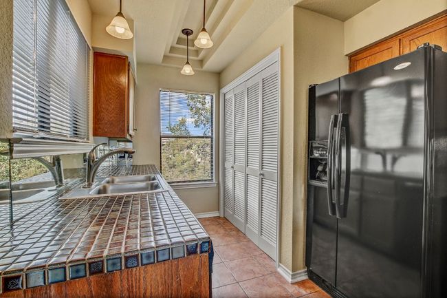 Kitchen with tile flooring and built in laundry area and windows to let in natural light | Image 13