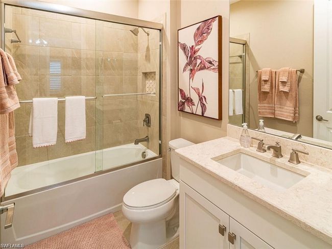 Full bathroom featuring combined bath / shower with glass door, vanity, and toilet | Image 13
