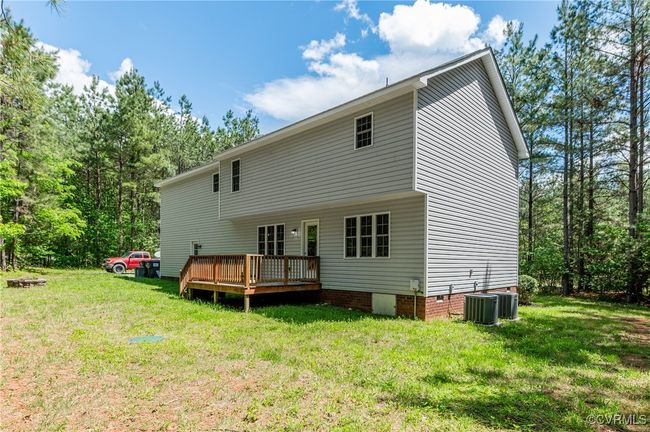 Back of house with a wooden deck, a lawn, and crawl space | Image 29