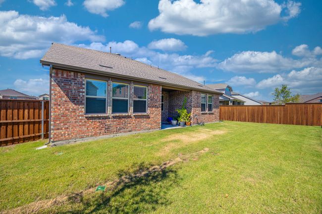Rear view of house featuring brick siding, a fenced backyard, and a shingled roof | Image 27