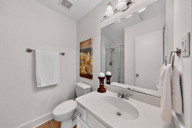 Bathroom with a shower stall, vanity, and tile patterned floors | Image 31
