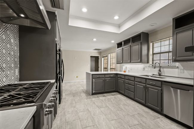 Kitchen with dishwasher, extractor fan, gray cabinetry, a peninsula, and plenty of natural light | Image 14