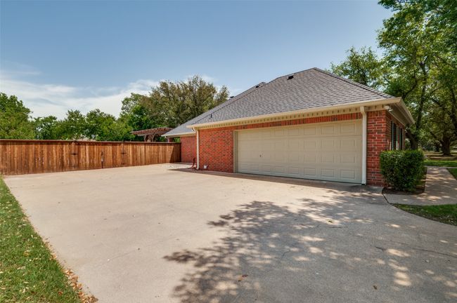 View of home's exterior featuring brick siding, fence, and a shingled roof | Image 29