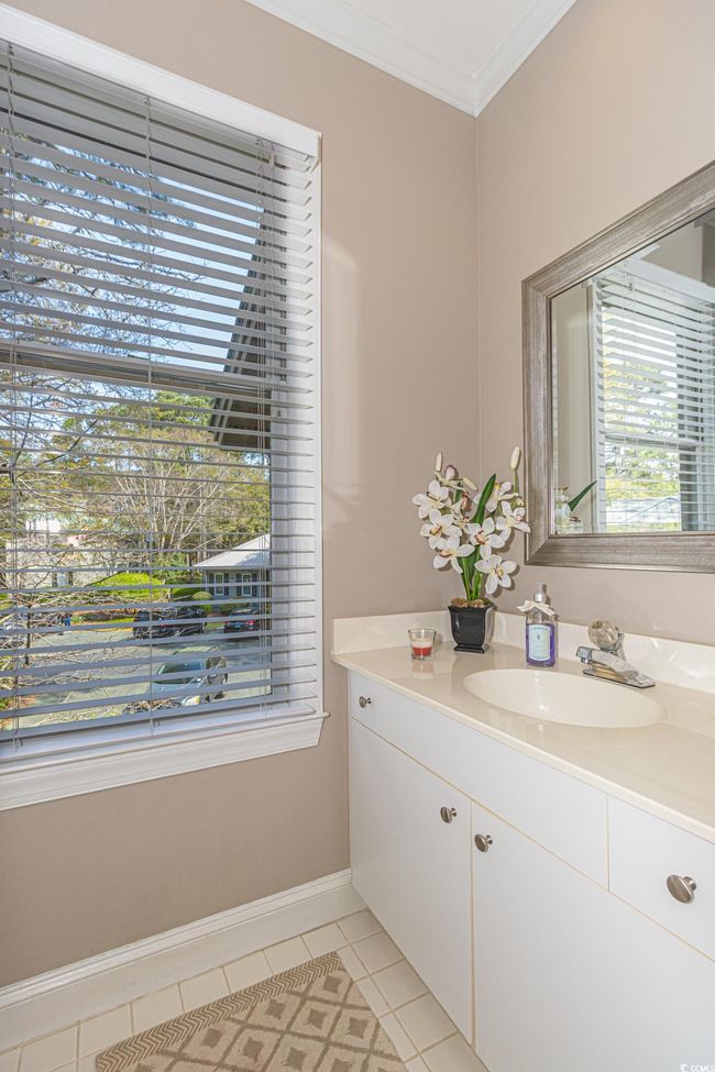 Bathroom featuring vanity, baseboards, tile patterned flooring, and ornamental molding | Image 31