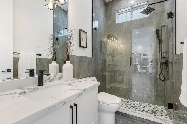 Full bathroom featuring tile walls, toilet, vanity, and a shower stall | Image 18