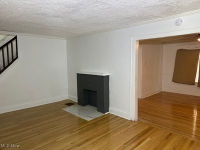 Unfurnished living room featuring wood-type flooring, a textured ceiling, and ceiling fan | Image 3