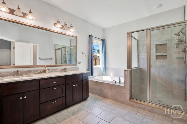 Sizable Owner's bath offering double vanities with granite countertops, garden tub, spacious tiled shower and private water closet | Image 25