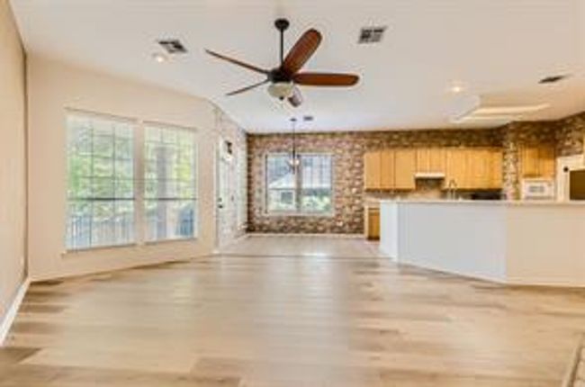Unfurnished living room featuring wood finished floors, a ceiling fan, and recessed lighting | Image 8