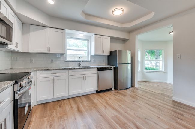 Kitchen featuring plenty of natural light, baseboards, a sink, and appliances with stainless steel finishes | Image 11