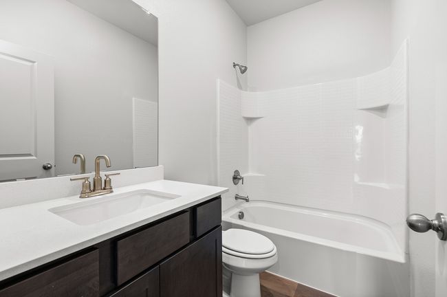 Full bath featuring vanity, shower / tub combination, and wood finished floors | Image 6