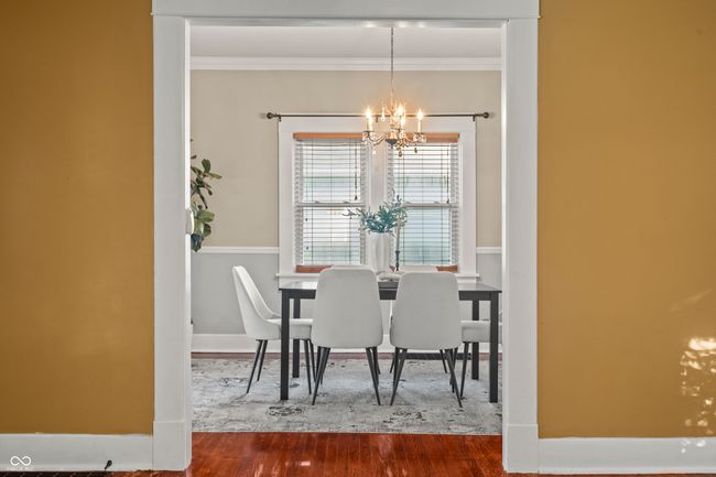 dining room with a chandelier, wood finished floors, and ornamental molding | Image 11