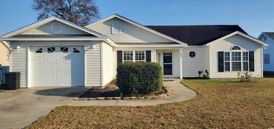 Ranch-style home with a front lawn and a garage | Image 1