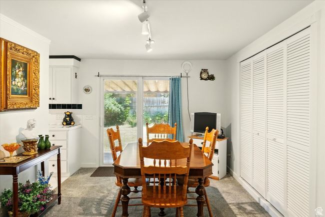 Dining space featuring light colored carpet, rail lighting, and baseboards | Image 10
