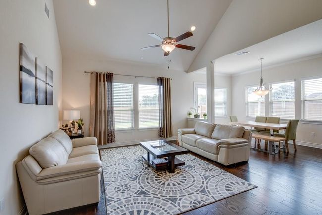 Living area with dark wood-style flooring, a ceiling fan, baseboards, recessed lighting, and visible vents | Image 8