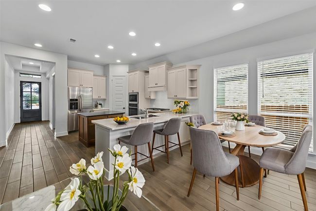 Dining room with dark wood-style flooring and recessed lighting | Image 9
