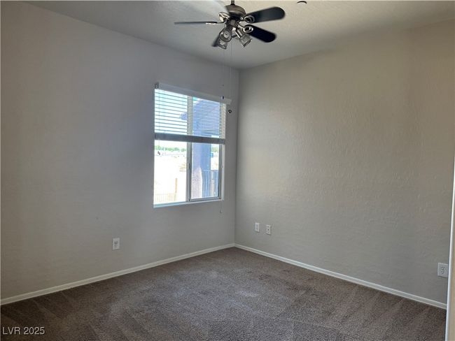 Unfurnished room featuring a ceiling fan and dark carpet | Image 15