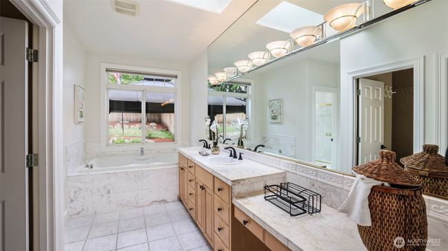 This en suite bathroom features a skylight and a walk-in closet that adds valuable extra storage to the primary living space! | Image 11