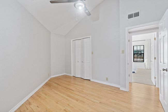 Unfurnished bedroom with visible vents, baseboards, high vaulted ceiling, and light wood finished floors | Image 17