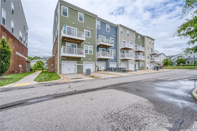 View of apartment building / complex featuring a garage and concrete driveway | Image 30