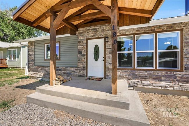 Doorway to property with stone siding and board and batten siding | Image 28