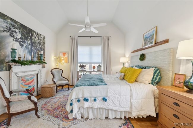 Bedroom featuring a brick fireplace, wood finished floors, ceiling fan, and vaulted ceiling | Image 19