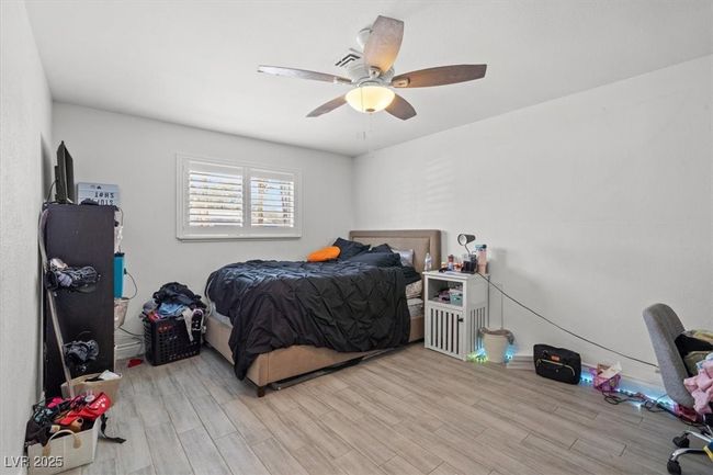 Bedroom with ceiling fan and light wood-style floors | Image 15