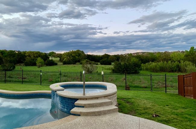 View of pool featuring a fenced backyard and a pool with connected hot tub | Image 27