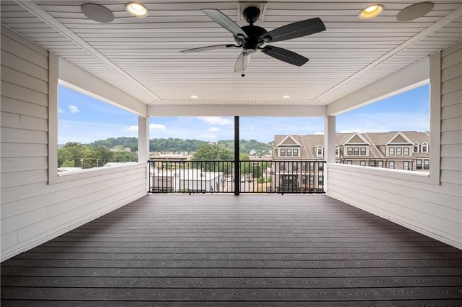 Third floor covered deck with recessed lights, ceiling fan, speakers and low maintenance floor and railing. | Image 36