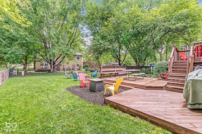 fenced backyard featuring a deck, stairs, and a fire pit | Image 32