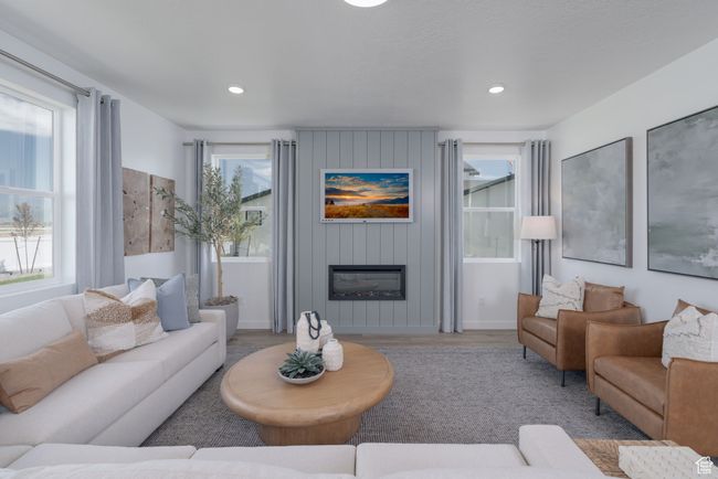 Living area with healthy amount of natural light, a fireplace, wood finished floors, and recessed lighting | Image 25