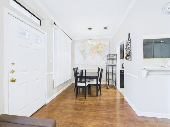 Dining room with ornamental molding, dark wood-style flooring, and healthy amount of natural light | Image 9
