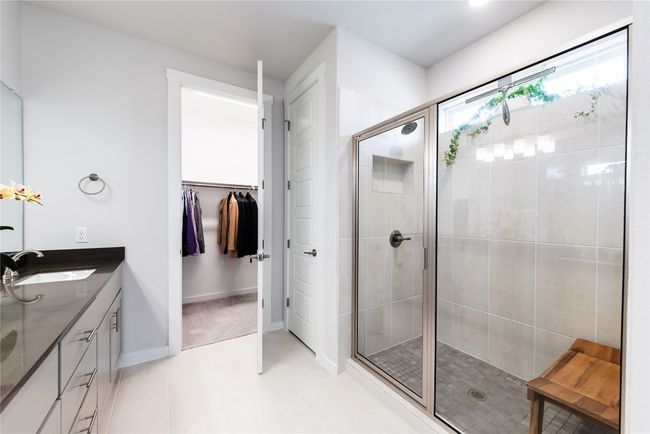 Bathroom with baseboards, double vanity, a sink, a stall shower, and a spacious closet | Image 17