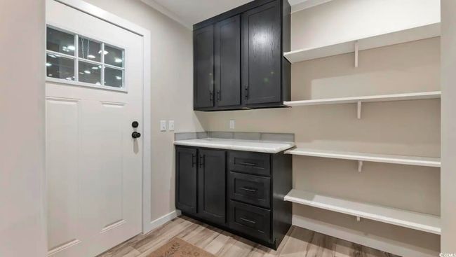 Laundry room with light wood finished floors and baseboards | Image 11