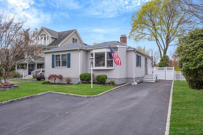 Bungalow featuring a chimney, a front lawn, fence, and a shingled roof | Image 6