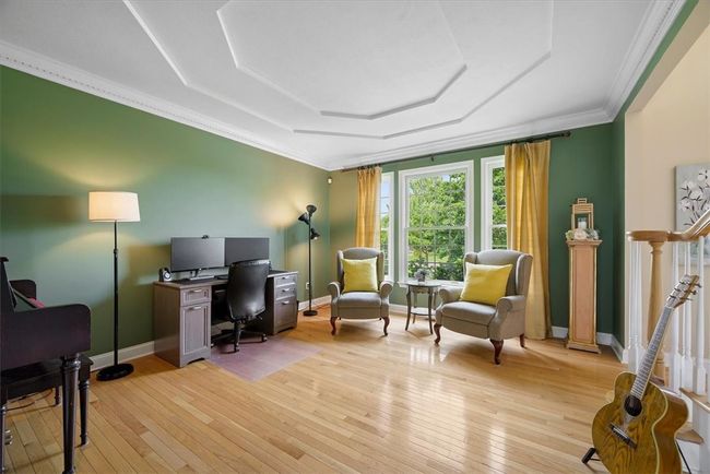 The living room is accented with a double tray ceiling and crown molding. | Image 9