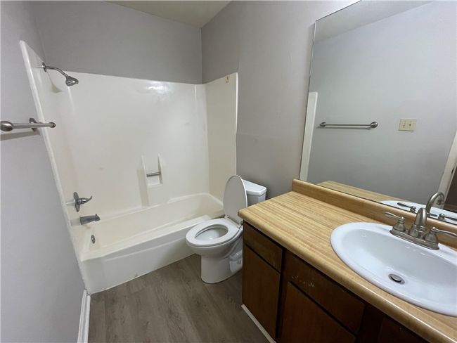 Full bathroom with hardwood / wood-style floors, vanity, toilet, and shower / washtub combination | Image 15