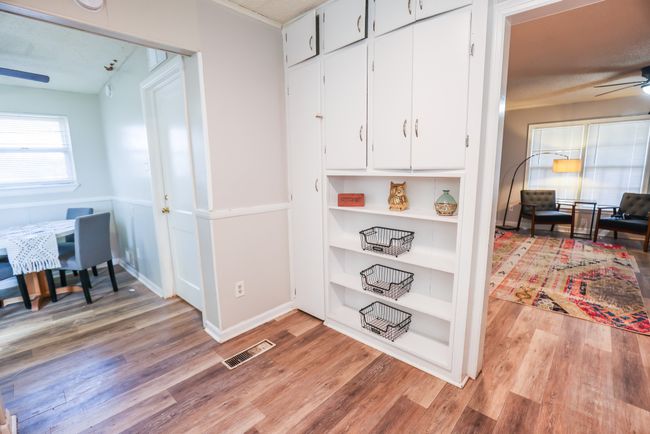 Corridor with light wood-style floors, visible vents, and baseboards | Image 10
