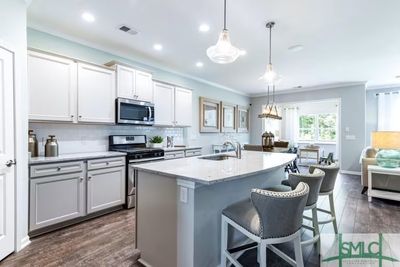 Bright kitchen with convenient center island. Pictures are of a model home. *Pictures, photographs, colors, features, and sizes are for illustration purposes only and will vary from the homes as built.* | Image 3