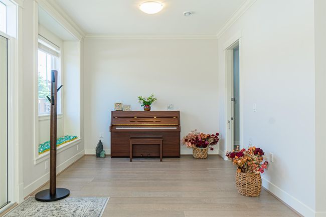 Living area with ornamental molding, light wood finished floors, and baseboards | Image 11