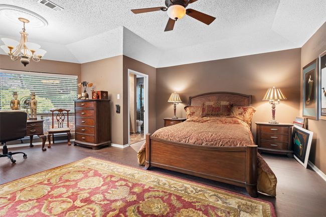 Bedroom featuring baseboards, wood finished floors, visible vents, and a textured ceiling | Image 12