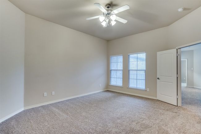 Large primary bedroom featuring carpet flooring, baseboards, and a ceiling fan | Image 16