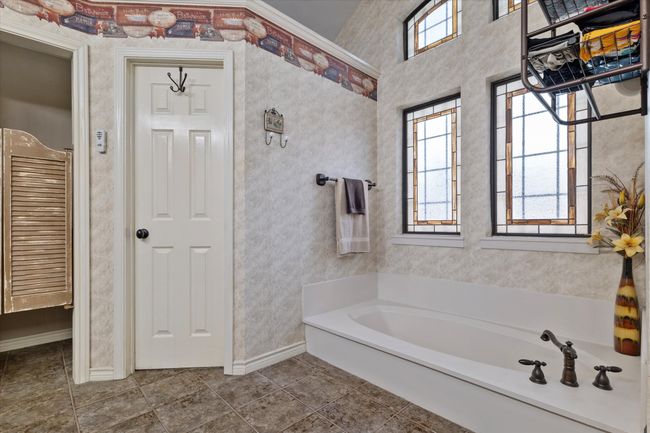 Bathroom with a garden tub and baseboards | Image 24
