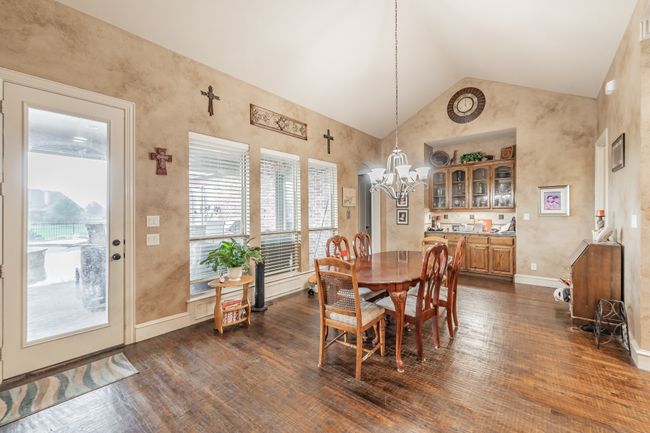 Dining room featuring dark wood-style floors, a chandelier, and high vaulted ceiling | Image 14
