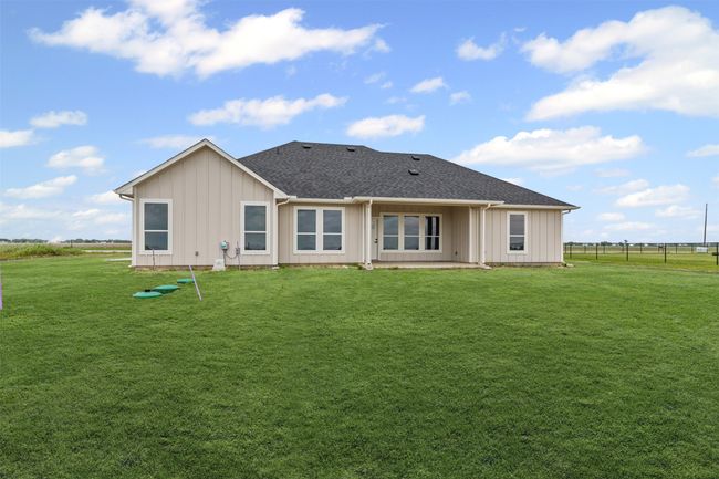 Back of property with board and batten siding, fence, and a yard | Image 40