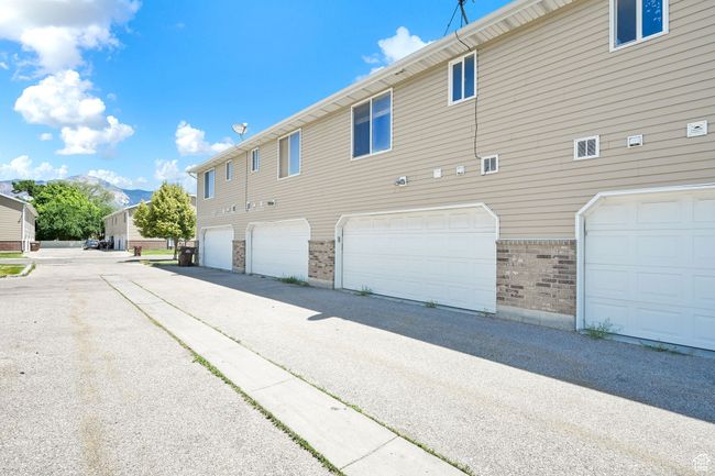 View of property exterior featuring brick siding, a mountain view, and an attached garage | Image 26