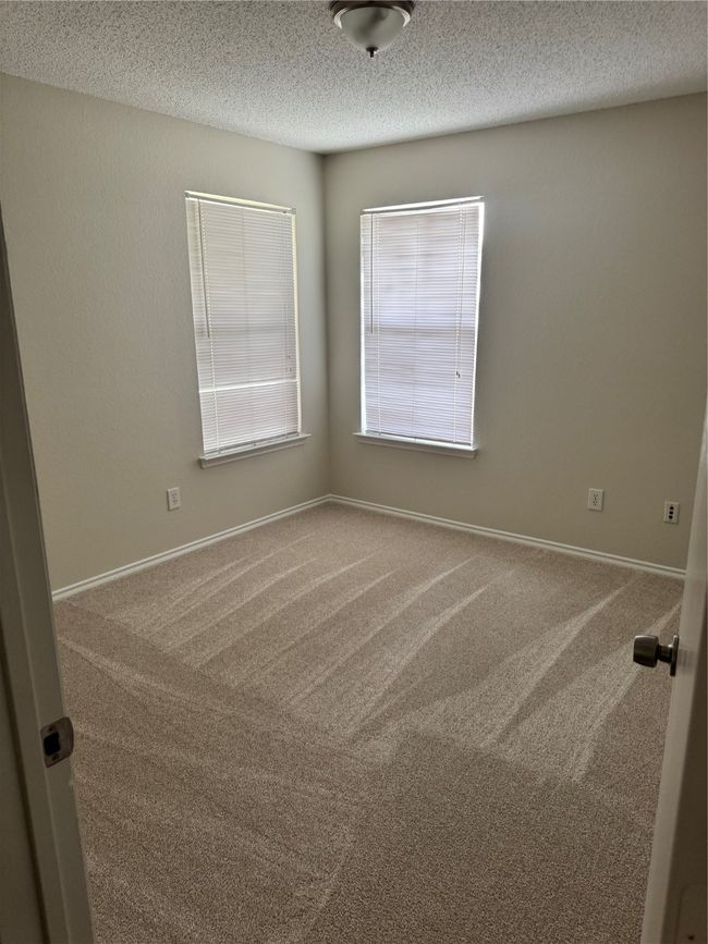 Spare room featuring carpet floors, a textured ceiling, and baseboards | Image 13