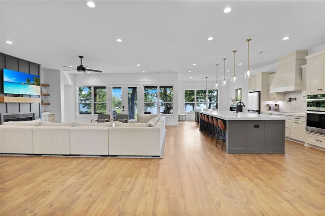 Living area with ceiling fan, recessed lighting, light wood finished floors, and a fireplace | Image 6