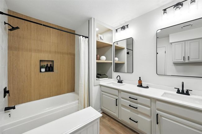 Bathroom with double vanity, shower / bath combo with shower curtain, and wood finished floors | Image 23