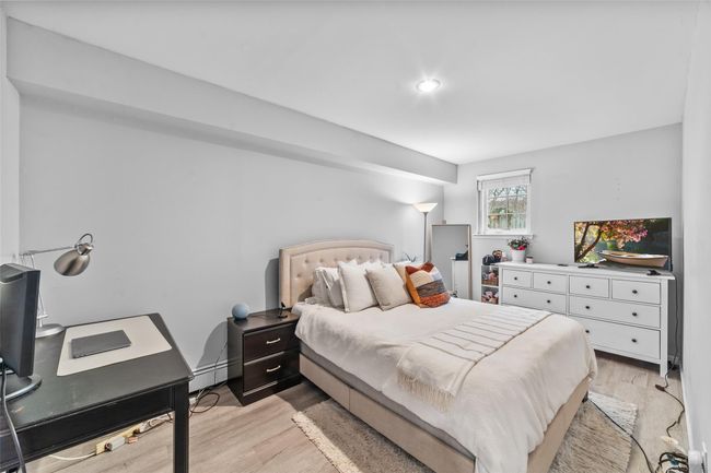 Bedroom with a baseboard heating unit and light wood-style floors | Image 36