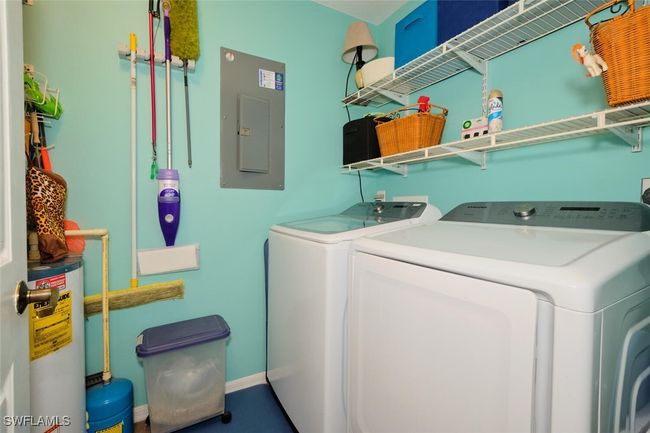 Laundry room featuring electric panel, electric water heater, and independent washer and dryer | Image 30